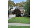 Charming two-story brick home featuring a manicured lawn, lush trees and a delightful periwinkle front door at 307 Kellyridge Dr, Apex, NC 27502