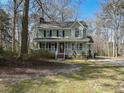 Charming two-story home boasts a welcoming porch and beautiful green lawn and mature landscaping at 3313 Ventura Cir, Wake Forest, NC 27587
