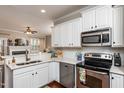 Modern kitchen with white cabinets, stainless steel appliances, and ample counter space at 345 Anterbury Dr, Apex, NC 27502