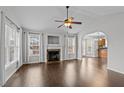 Bright living room featuring vaulted ceilings, a cozy fireplace, and dark hardwood floors, seamlessly connects to dining area at 35 Flume Rd, Franklinton, NC 27525