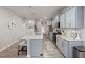 Stunning kitchen features light blue cabinets, stainless appliances, island with seating and quartz counters at 508 Sweet Pine Ln, Knightdale, NC 27545
