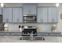 Modern kitchen features stainless steel appliances, granite countertops, and stylish blue cabinets at 508 Sweet Pine Ln, Knightdale, NC 27545