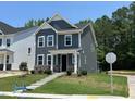 Charming two-story home with gray siding, stone accents, and lush green landscaping at 5640 Cayden Cove Dr, Wendell, NC 27591