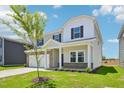 Two-story home with brick and vinyl siding, with an attached two-car garage and a manicured lawn at 571 White Birch Ln, Angier, NC 27501