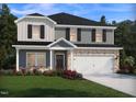Charming two-story home with landscaped yard and a two-car garage, blending brick and siding at 571 White Birch Ln, Angier, NC 27501