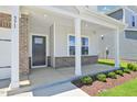 A welcoming covered front porch framed by brick pillars and manicured landscaping at 571 White Birch Ln, Angier, NC 27501
