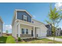 Two-story home featuring a covered front porch, and a well-maintained lawn at 591 White Birch Ln, Angier, NC 27501