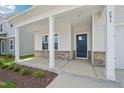 A charming covered front porch of a home with brick accents and white pillars at 591 White Birch Ln, Angier, NC 27501