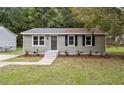 Charming single-story home with a well-manicured lawn, freshly mulched flower beds, and updated siding at 610 Pineland St, Sanford, NC 27330