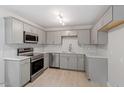 Modern kitchen featuring stainless steel appliances, gray cabinets, and marble countertops at 610 Pineland St, Sanford, NC 27330