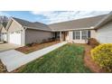 Beautiful single-story home with an attached garage, charming yard, and inviting front entrance at 653 Huntingdon St, Elon, NC 27244