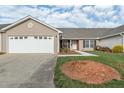 Lovely single-story home featuring an attached garage, manicured lawn, and a welcoming front entrance at 653 Huntingdon St, Elon, NC 27244