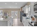 Bright open-concept kitchen featuring stainless steel appliances, granite countertops, white cabinets, and a large island at 656 Dallas Rose Dr, Wendell, NC 27591