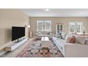 Bright living room with a large rug, comfortable seating, and a modern entertainment center at 656 Dallas Rose Dr, Wendell, NC 27591