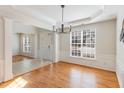 Bright dining room with hardwood floors, large window, elegant lighting, and decorative molding at 7533 Silver View Ln, Raleigh, NC 27613