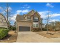 Two-story home featuring a two-car garage, brick accents, and a well-maintained lawn at 8304 Rosiere Dr, Cary, NC 27518