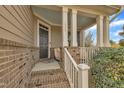 Inviting front porch with brick columns, white railings, and a view of the home's entrance at 8304 Rosiere Dr, Cary, NC 27518