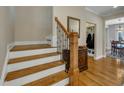 Staircase with wooden steps, white risers, and a wrought iron and wood banister at 8304 Rosiere Dr, Cary, NC 27518