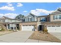 Charming two-story home featuring a brick facade, a two-car garage, and a welcoming front porch with decorative wreath at 938 Haybeck Ln, Apex, NC 27523