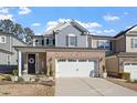 Inviting two-story home features a beautiful brick facade, a black front door, and a two-car garage at 938 Haybeck Ln, Apex, NC 27523