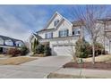 Inviting two-story house featuring a two-car garage, manicured lawn, and stone-accented covered porch at 100 Highveld Ave, Chapel Hill, NC 27516