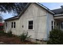 Side view of the residence showing the exterior siding, windows, and surrounding greenery at 1005 N Wilson Ave, Dunn, NC 28334