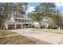 Traditional two-story home with attached garage and long driveway, surrounded by mature trees at 1021 Whetstone Ct, Raleigh, NC 27615