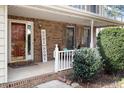 Cozy covered front porch with brick siding, comfortable seating, and a welcoming 'Home Sweet Home' sign at 1021 Whetstone Ct, Raleigh, NC 27615