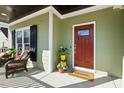Cozy front porch featuring stylish seating, potted plants, and a welcoming red front door at 1024 Jensen Grove Ct, Fuquay Varina, NC 27526