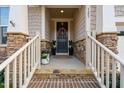 Inviting front porch with stone accents, decorative wreath, and a cozy, welcoming ambiance at 105 Olde Liberty Dr, Youngsville, NC 27596
