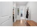 Bright hallway featuring wood floors, white trim, laundry closet, and an inviting, well-lit atmosphere at 105 Olde Liberty Dr, Youngsville, NC 27596