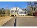 Inviting single-story home with a classic design, wooden porch, and a neatly paved driveway at 109 Faucette Ave, Burlington, NC 27215