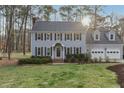 Charming two-story home with black shutters, gray siding, mature trees, and a well-manicured lawn at 1113 Harvest Mill Ct, Raleigh, NC 27610