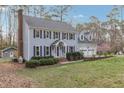 Charming two-story home with black shutters, gray siding, mature trees, and a well-manicured lawn at 1113 Harvest Mill Ct, Raleigh, NC 27610