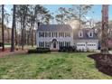 Charming two-story home with black shutters, gray siding, mature trees, and a well-manicured lawn at 1113 Harvest Mill Ct, Raleigh, NC 27610