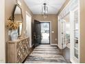 Inviting entryway featuring hardwood floors, stylish rug, decorative mirror, and ample natural light at 1214 Gaston Manor Dr, Durham, NC 27703