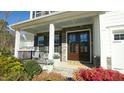 Charming front porch with stone accents, blue ceiling, and tastefully landscaped surroundings at 1532 Champlain Crest Way, Cary, NC 27513