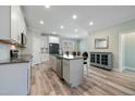 Bright kitchen featuring white cabinets, a central island, stainless steel appliances, and hardwood floors at 169 Black Cloud Dr, Louisburg, NC 27549