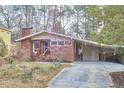 Charming brick home with a side carport and a blooming tree accenting the front yard at 2208 Tampa Ave, Durham, NC 27705