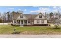 Inviting single-Gathering home featuring a well-manicured lawn, blossoming tree, and quaint mailbox at 225 Woodfield Ct, Fuquay Varina, NC 27526
