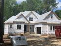 Unfinished home showing the framework and initial stages of construction in a partially wooded area at 249 High Ridge Ln, Pittsboro, NC 27312