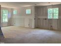Unfinished room shows a spacious interior with drywall and bright, natural light streaming through the windows at 249 High Ridge Ln, Pittsboro, NC 27312