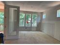 Bright unfinished room shows a view to a covered porch and lots of natural light through the large windows at 249 High Ridge Ln, Pittsboro, NC 27312