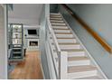 View of staircase and open-concept living area with fireplace beyond at 3080 Colony Rd # A, Durham, NC 27705