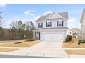 Charming home with light gray siding, black shutters, two-car garage and long driveway at 3103 Woodland Park Rd, Durham, NC 27703