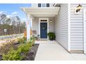 Welcoming front porch with blue door, wreath, rocking chair, and potted plant at 3103 Woodland Park Rd, Durham, NC 27703