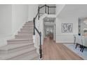 Bright foyer with staircase featuring black handrail and views into the living and dining areas at 315 Barthel Dr, Cary, NC 27513