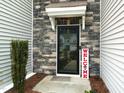 Close-up of stylish front door with stone surround and decorative welcome sign at 372 White Oak Ridge Dr, Garner, NC 27529