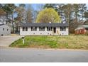 Charming single-story home with a well-maintained lawn and a classic white brick facade at 409 Avery St, Garner, NC 27529