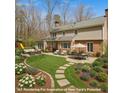 A beautifully landscaped backyard boasts a curved stone path, lush lawn, and an inviting outdoor seating area at 609 Brookview Dr, Chapel Hill, NC 27514